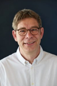 Foto eines der behandelnden Ärzte, er lächelt freundlich und zugewandt.