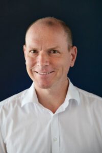 Foto eines der behandelnden Ärzte, er lächelt freundlich und zugewandt.